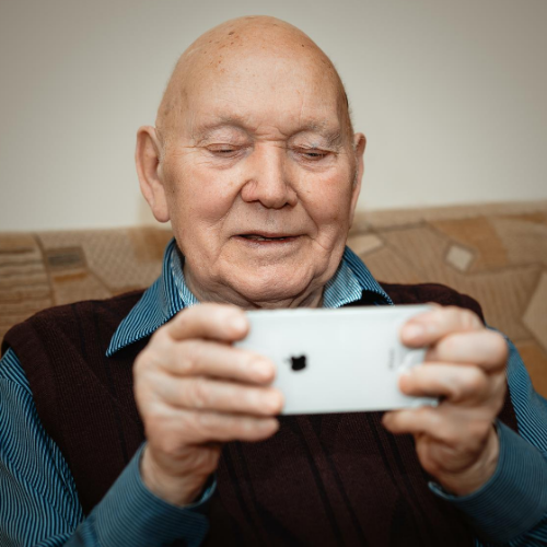 an elderly man holding a smartphone