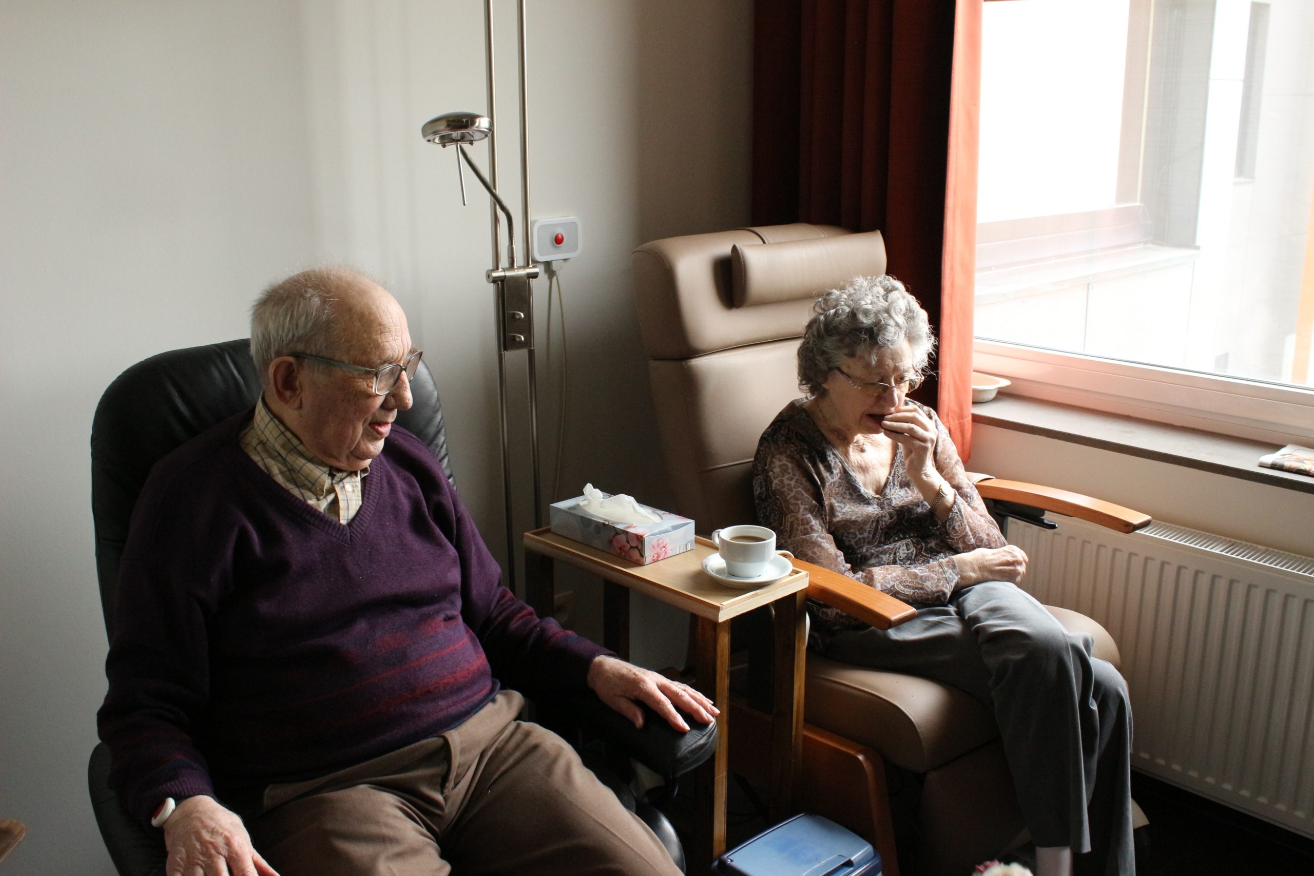 elderly man and woman sitting together reading