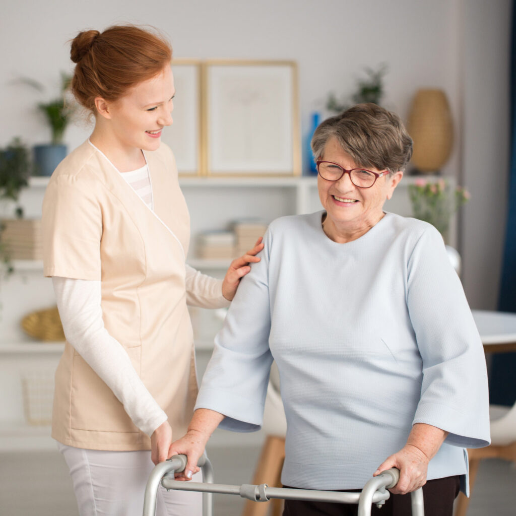 at home cargiver helping elderly woman using a walker