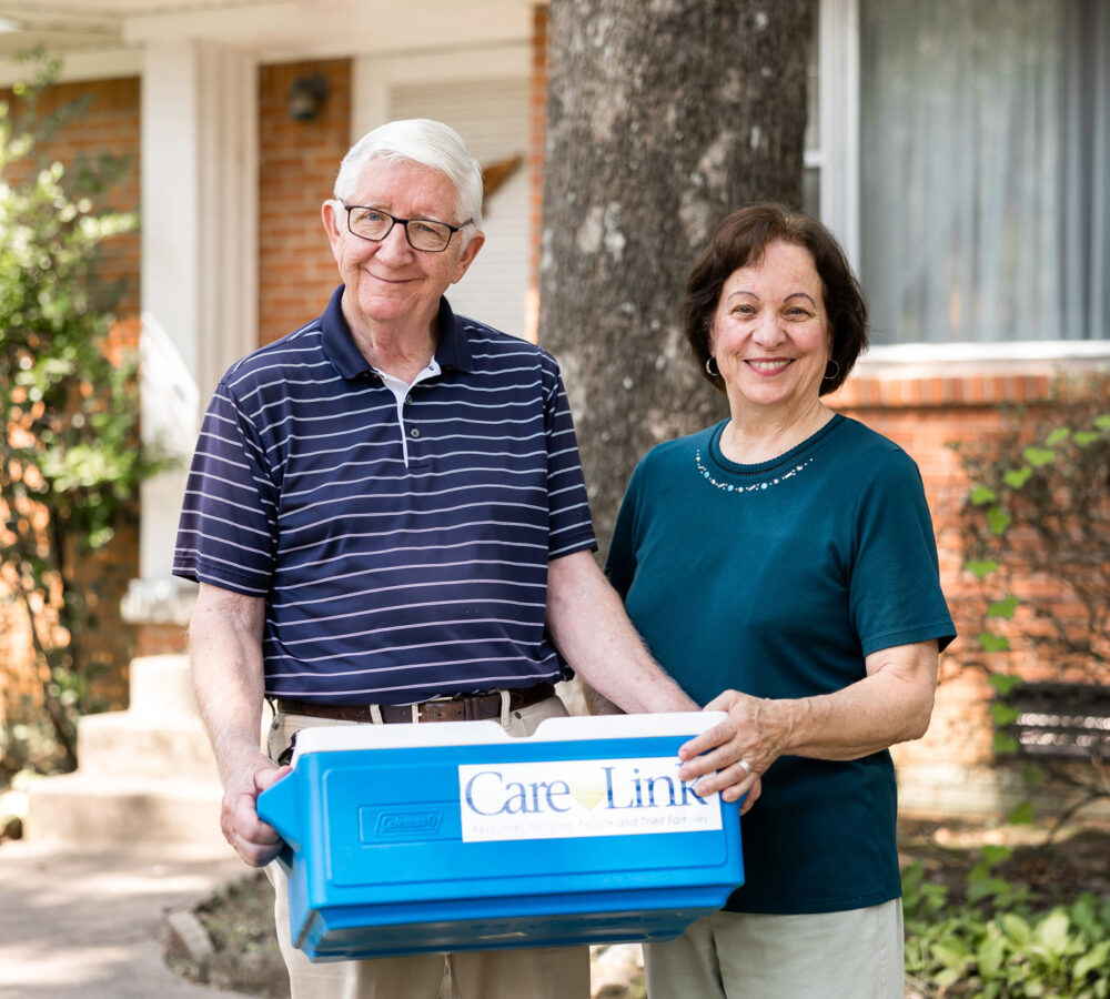 couple carrying a Meals on Wheels box