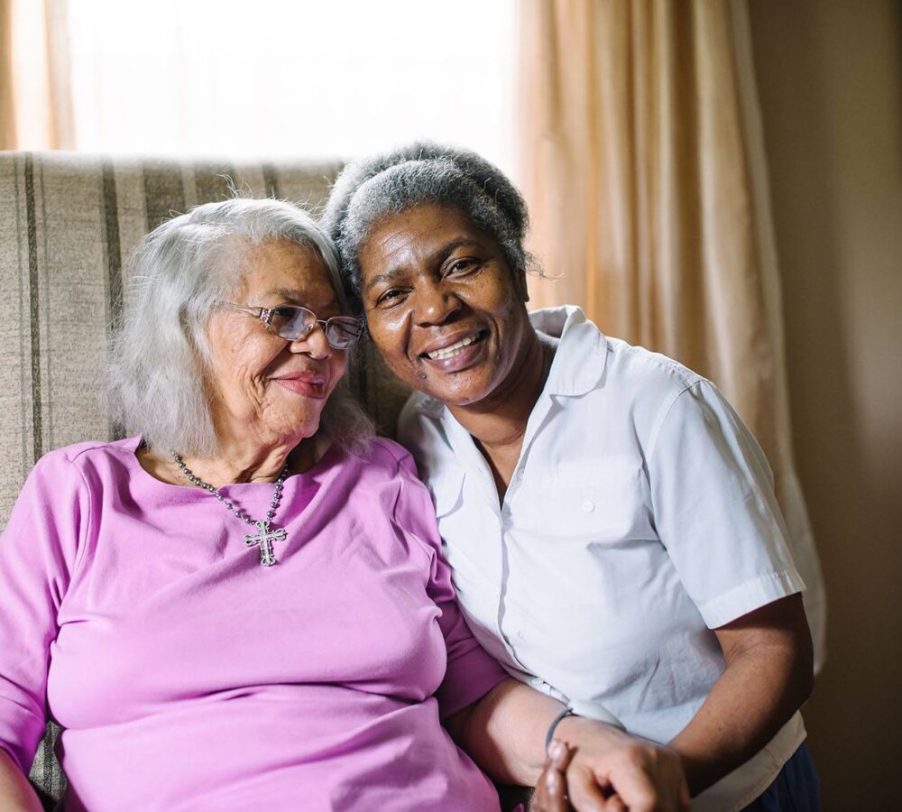 elderly woman smiling with her caregiver