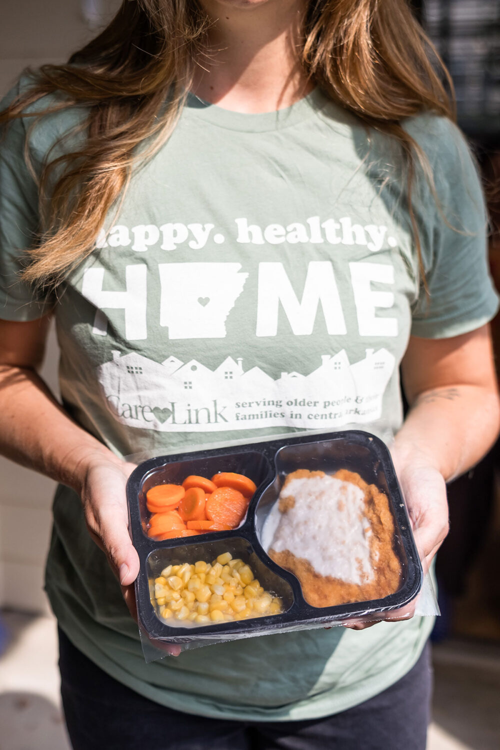 Meals on Wheels volunteer holding a packaged meal