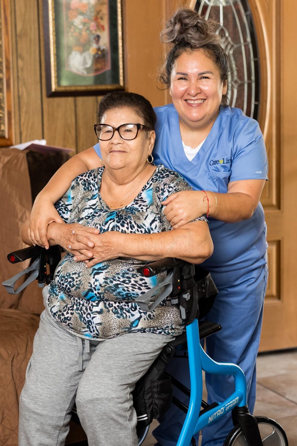 an elderly woman and her caregiver smiling together