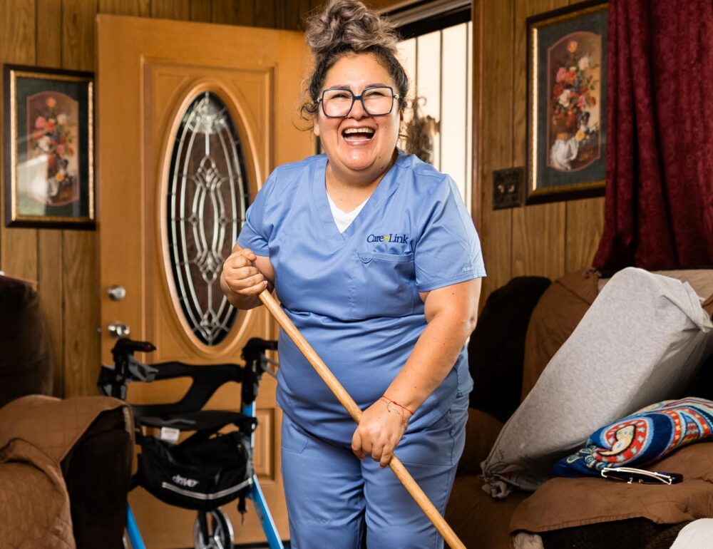 smiling homecare worker sweeping