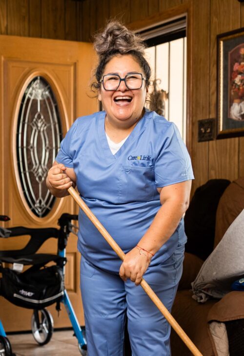 smiling homecare worker sweeping